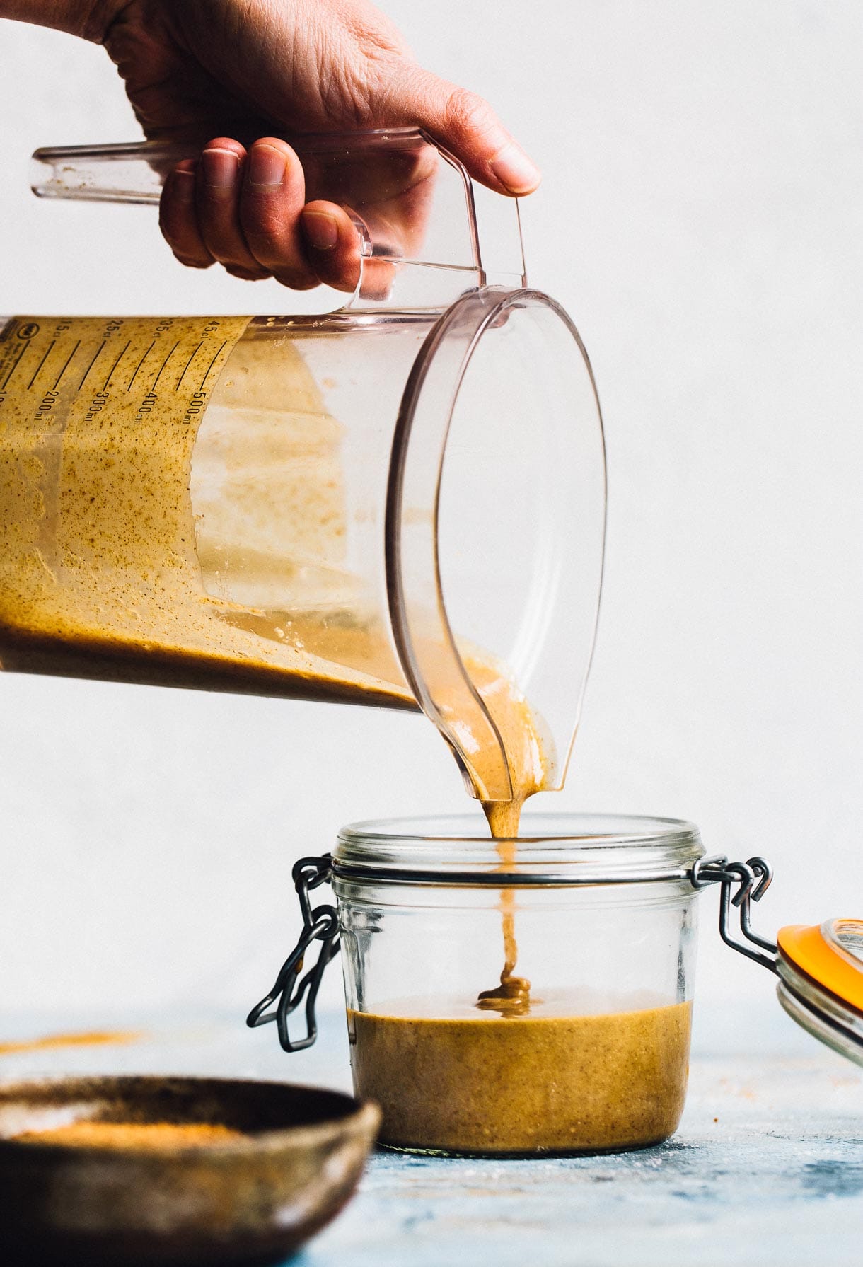 pouring homemade nut butter made in a blendtec