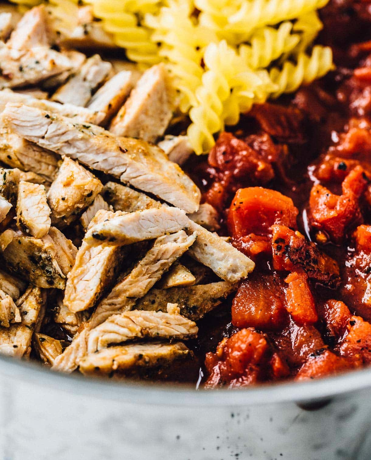 close up of cooked turkey cutlets and fire roasted tomatoes