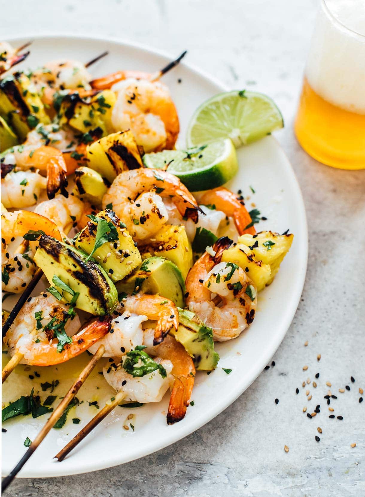 close up of grilled shrimp kabobs served with beer