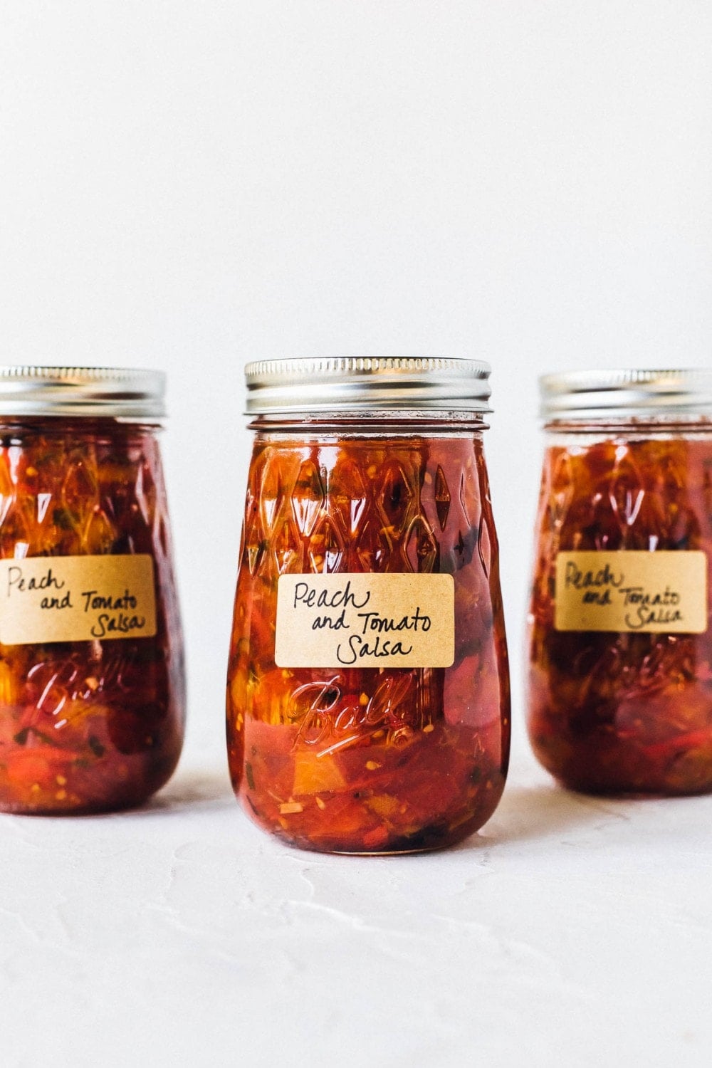 tomato peach salsa in ball canning jars with labels