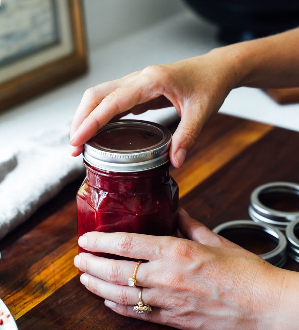 tightening the lid on a jar of salsa