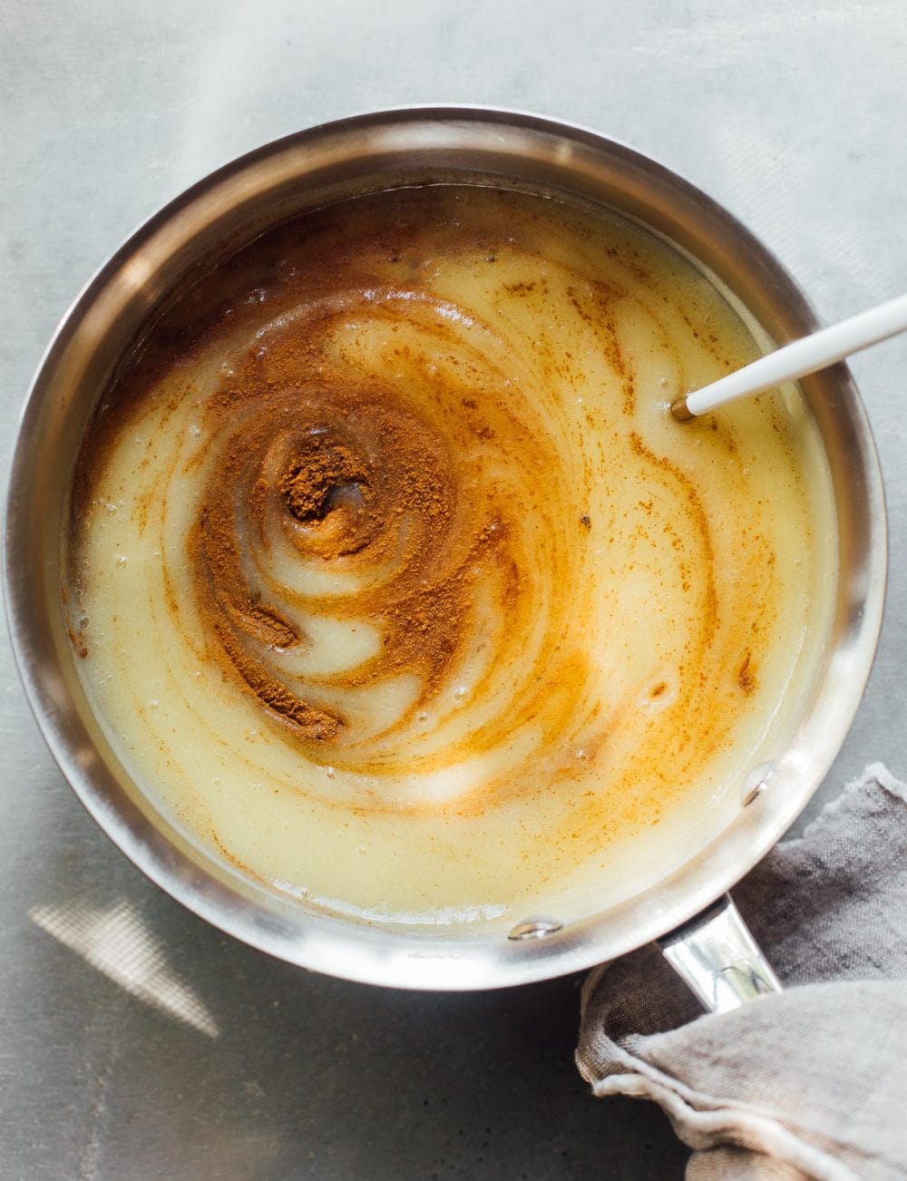 apple butter in a sauce pan, with cinnamon swirled in