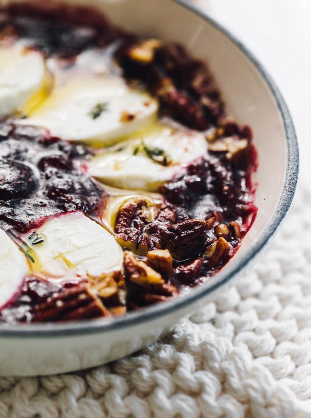 baked goat cheese with fig jam in a white cast iron skillet