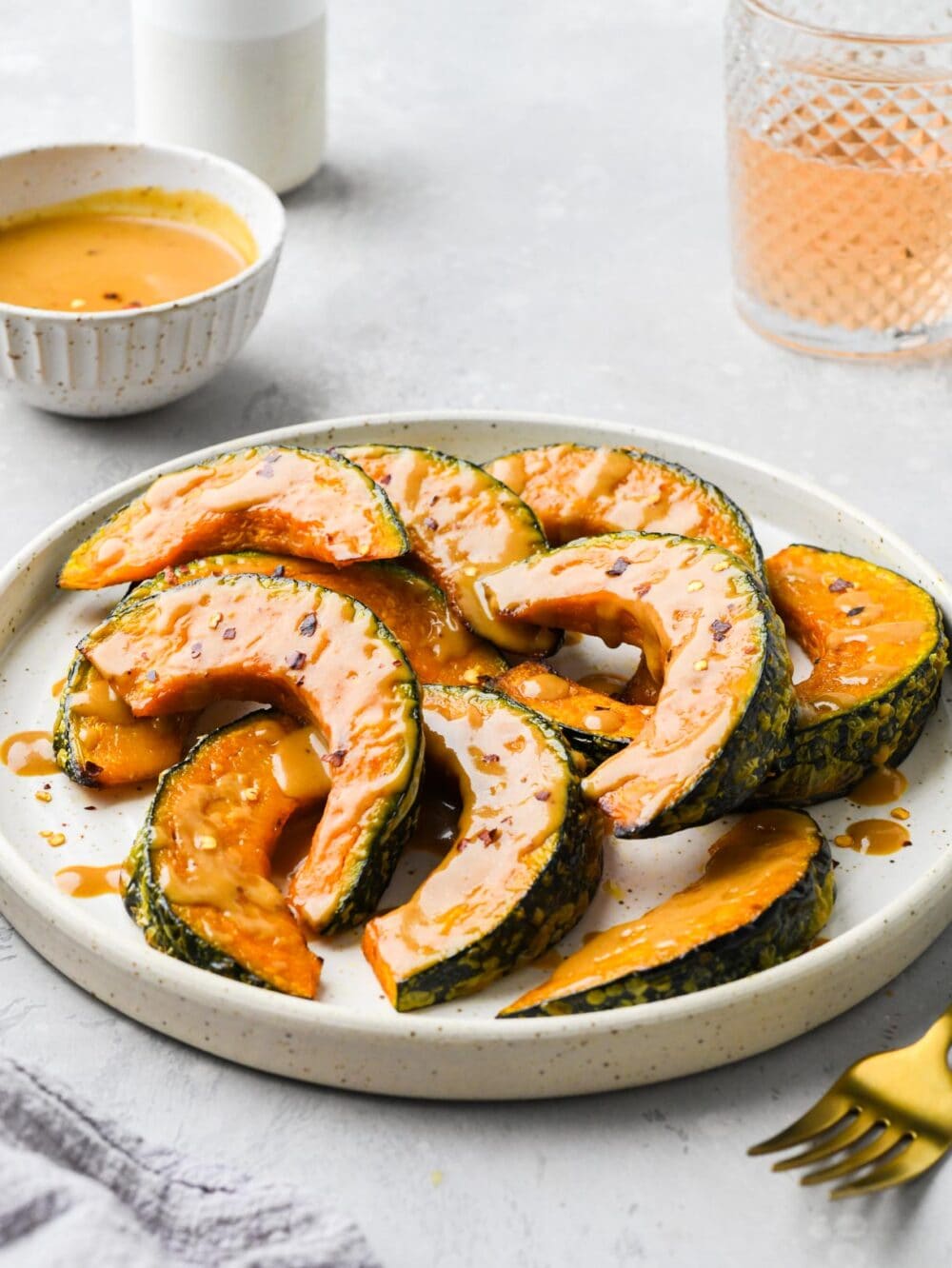 roasted kabocha squash wedges with miso glaze on a white plate