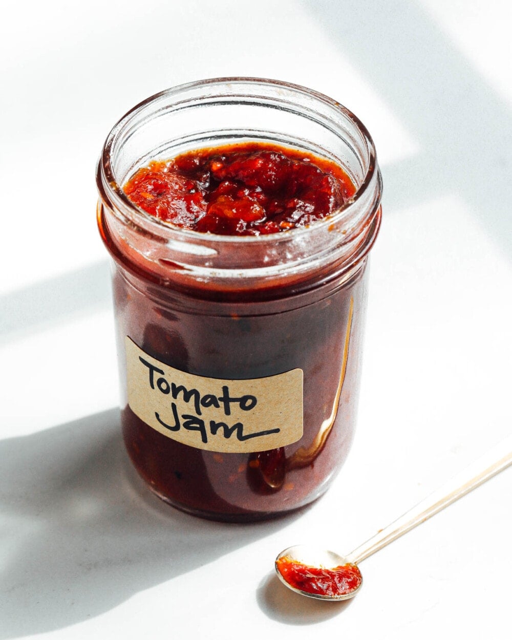 tomato jam in a jar with spoon out of it