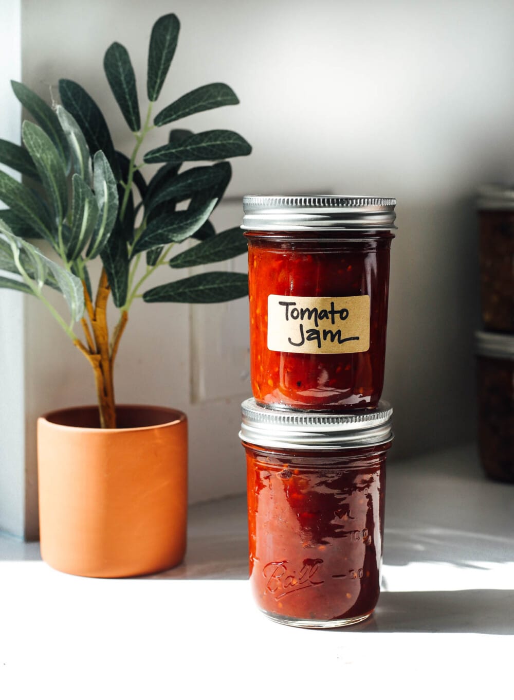 tomato jam in clear jams stacked on top of each other