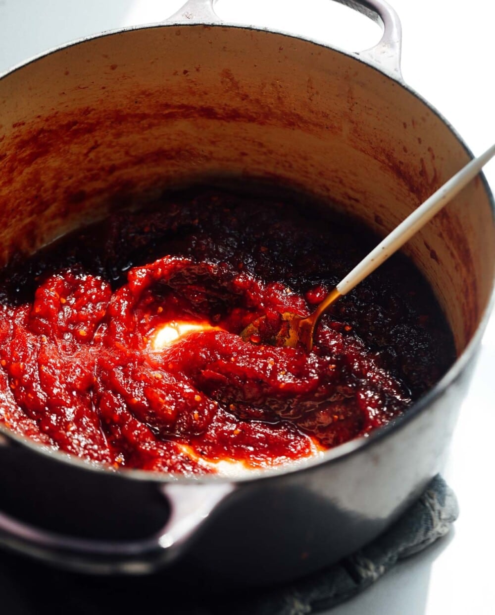 tomato jam in a pot with gold spoon