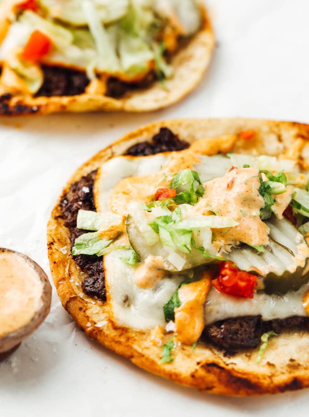 smash burger tacos with pickles on parchment paper