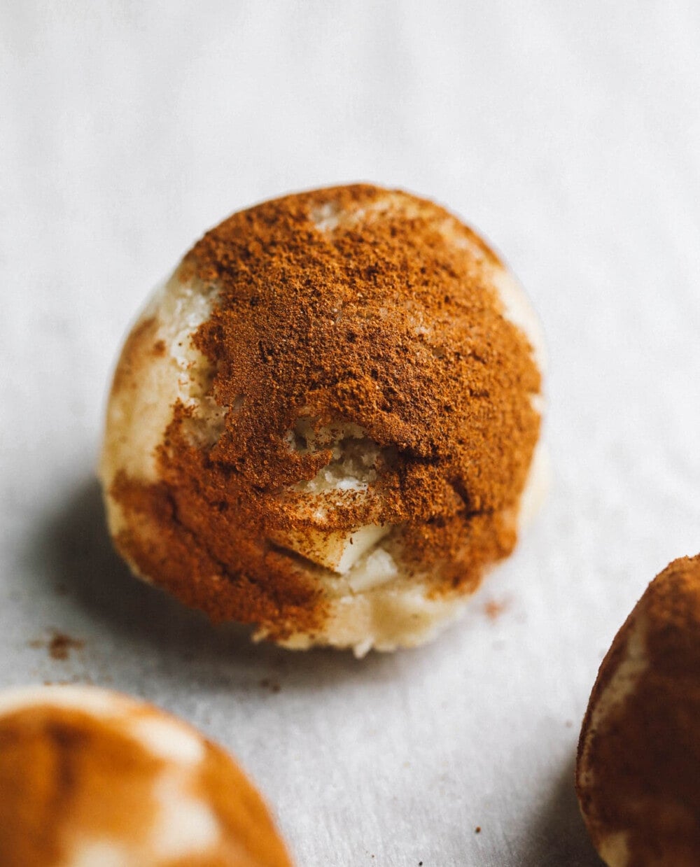 snickerdoodle dough balls on white parchment paper