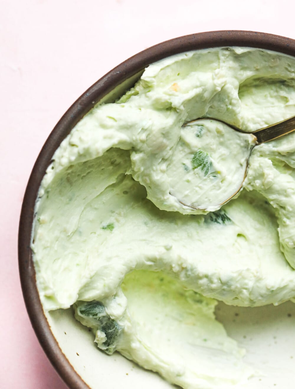 jalapeno cream cheese in a bowl with a gold spoon
