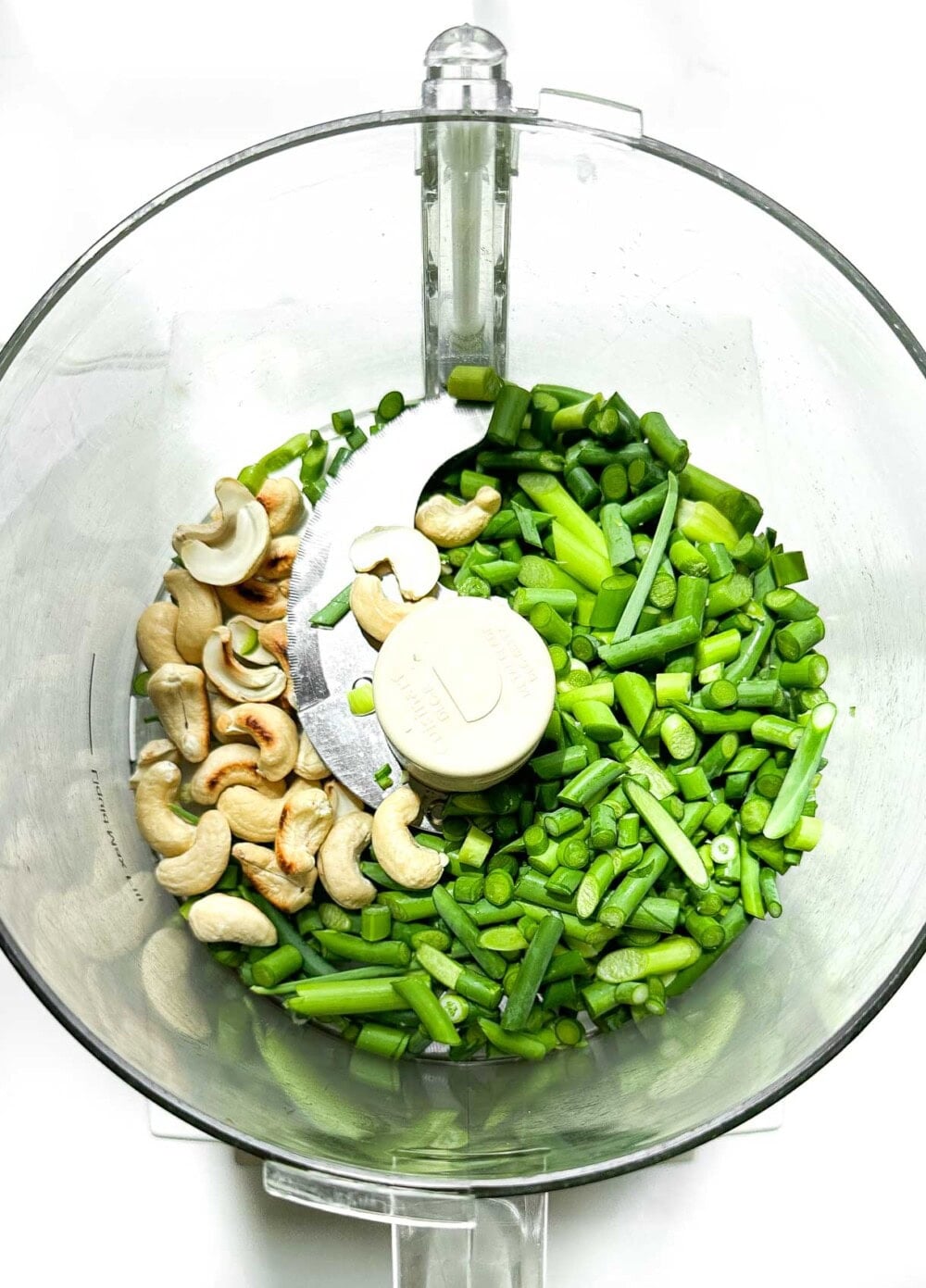 garlic scapes and cashews in a food processor