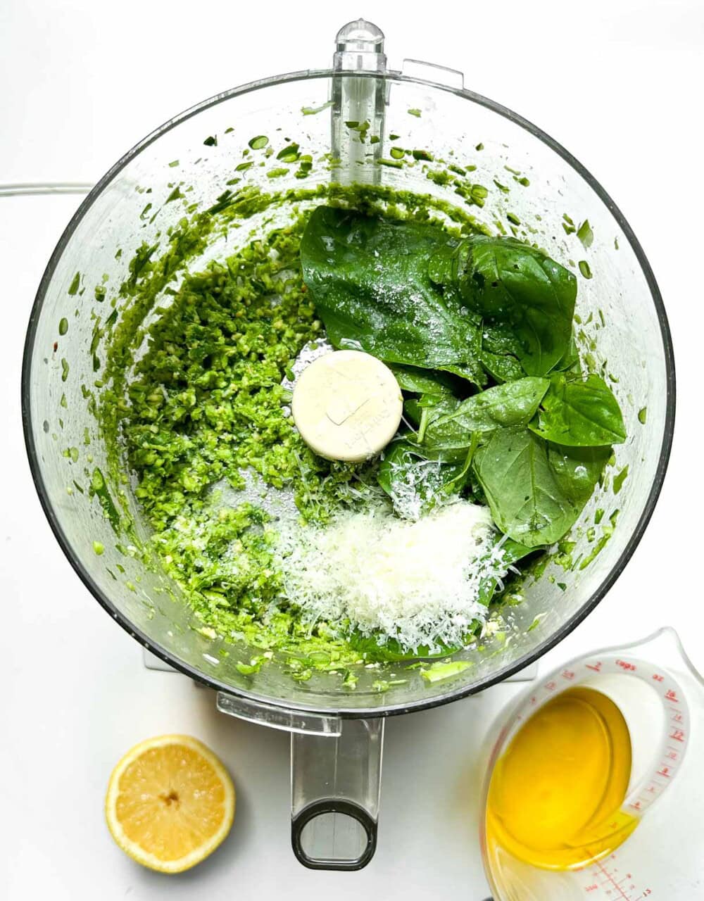 garlic scape pesto with basil leaves and Parmesan in a food processor