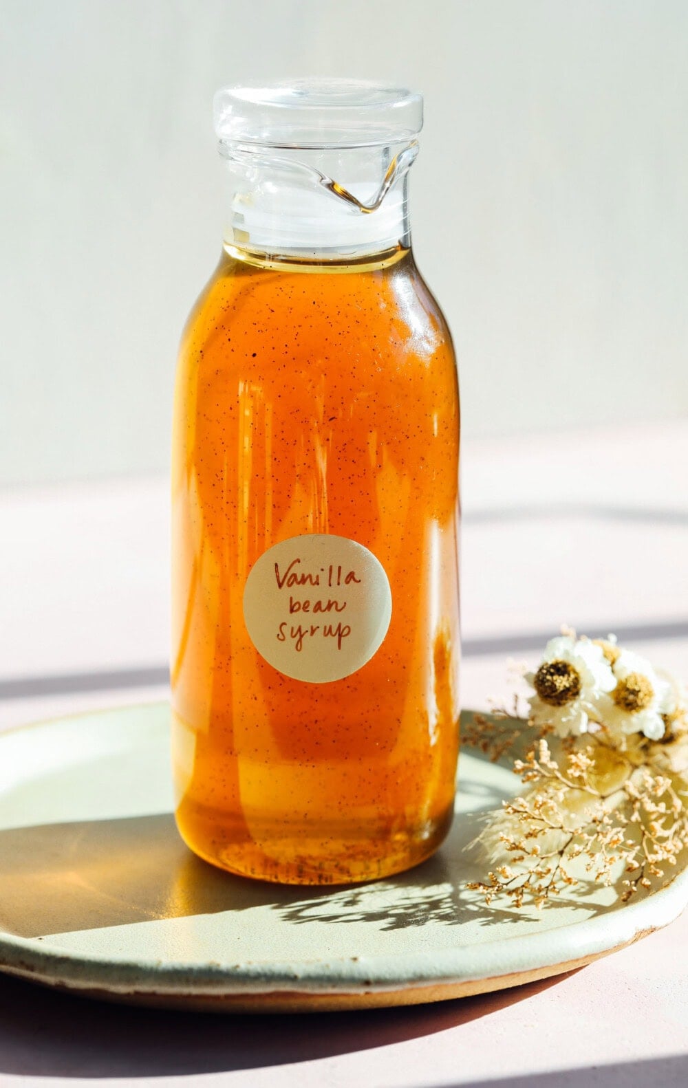 vanilla bean syrup in a glass bottle on a plate
