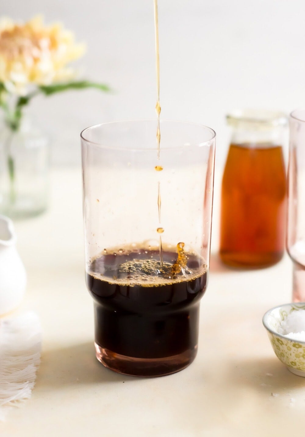pouring simple syrup into a glass with espresso