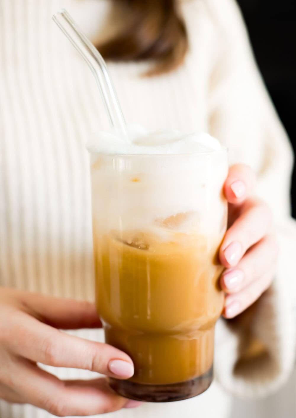 woman holding an iced vanilla latte
